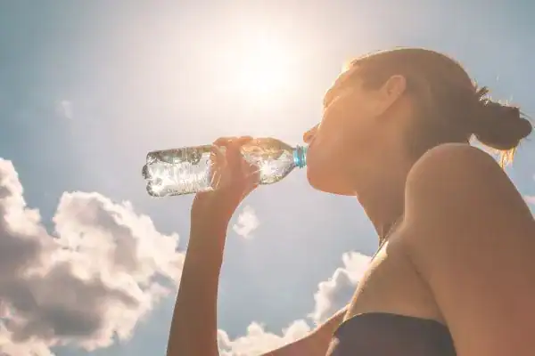 Hydration: The Secret Ingredient for a Toned Stomach and Enhanced Fitness 3 Image of woman drinking water to hydrate Guildford after run.
